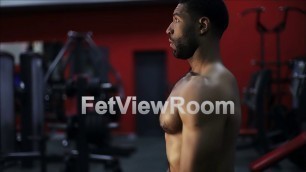 'Naked black man is preparing for training in the gym.'