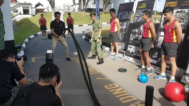 'Ong Ye Kung trying out the battle ropes exercise at the CESP opening'